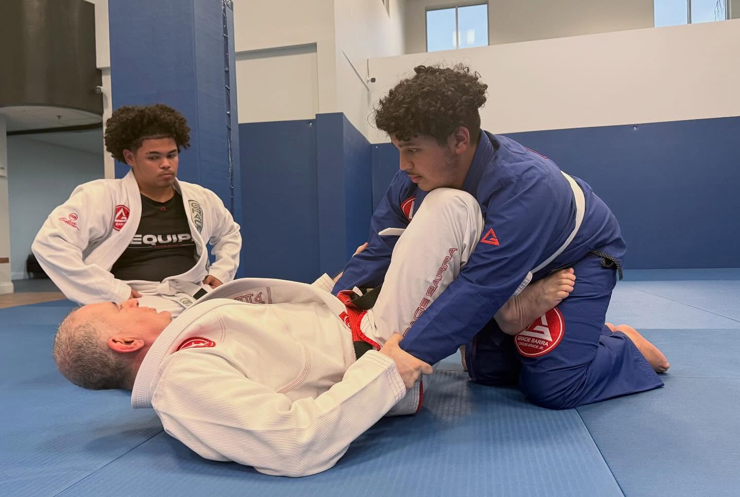 Brazilian Jiu-Jitsu team members gathered together on the mats at the Gracie Barra Sanford training academy
